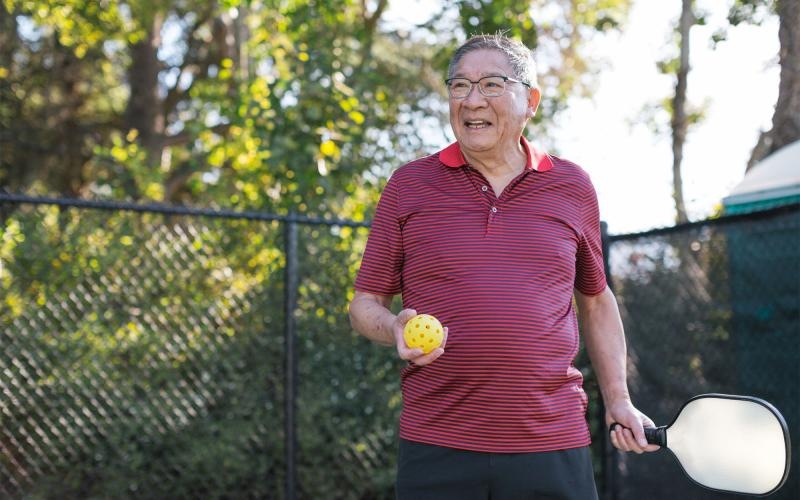 a man holding a Pickleball racket